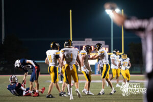 Players celebrate during a game on an outdoor field.