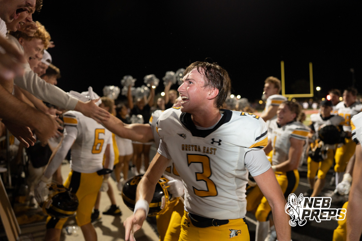 Players celebrate during a game on an outdoor field.