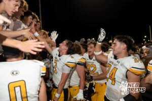 Players celebrate during a game on an outdoor field.