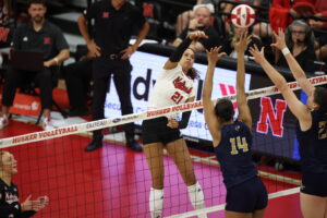 Skyler Pierce swings over the top of two Georgia Tech defenders in Nebraska volleyball's 3-1 victory. Photo by Braden Cochran.