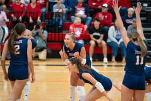 The Titans celebrate after the match-point kill from Alli Bornschlegl (2). Photo by Jackson D. Luethje.