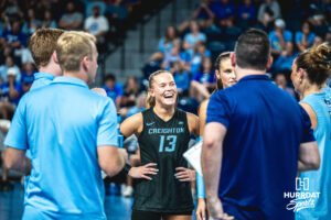 Saige Damrow (13) smiles in the huddle during a timeout in a home game against the Kansas State Wildcats on September 18, 2026 in Omaha, Nebraska. Photo by Rob Olvera.