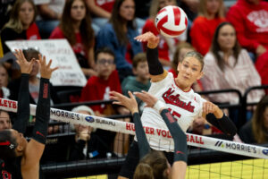 Andi Jackson swings over two Rutgers blockers for one of her 14 kills. Photo by Braden Cochran.