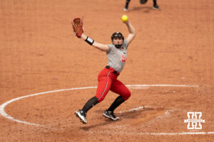 A Nebraska player delivers a pitch in a college softball game.