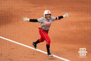 Natalia Hill celebrates as she runs the bases in a college softball game.