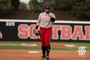 Alexis Jensen points toward a teammate from the infield in a college softball game.