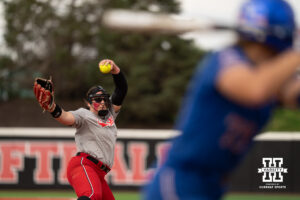 Alexis Jensen delivers a pitch to a Kansas player in a college softball game.