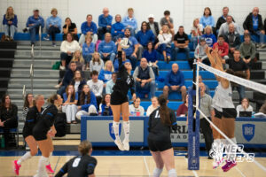 Fallyn O'Connell spikes the ball as a Papillion-LaVista South player goes up for a block in a high school volleyball match.
