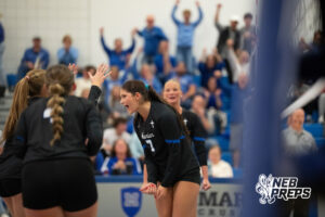 Trinity Rocha celebrates a point with teammates in a high school volleyball match.