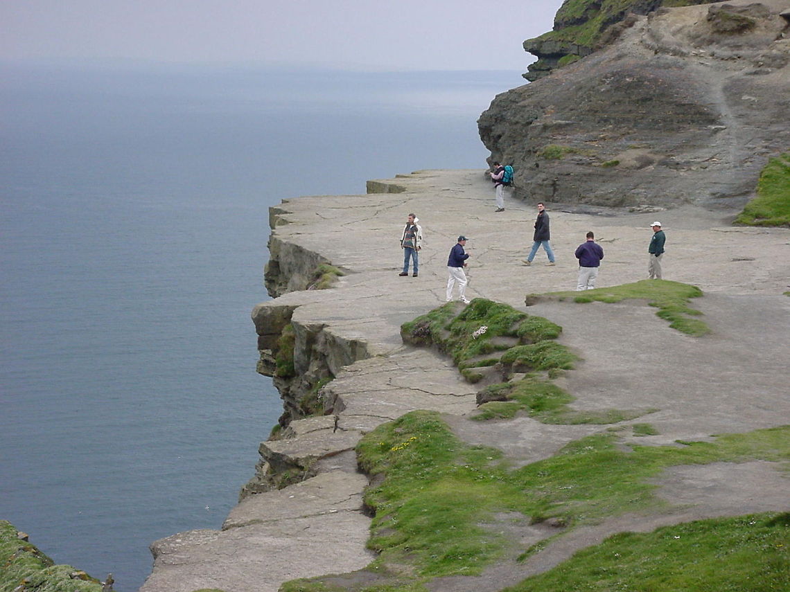 Cliffside detail These people are walking on the ledge, not far from the visitors centre of the Cliffs of Moher, Ireland. At this point, the ocean is 214 meters lower Cliffs of Moher,Europe,Ireland