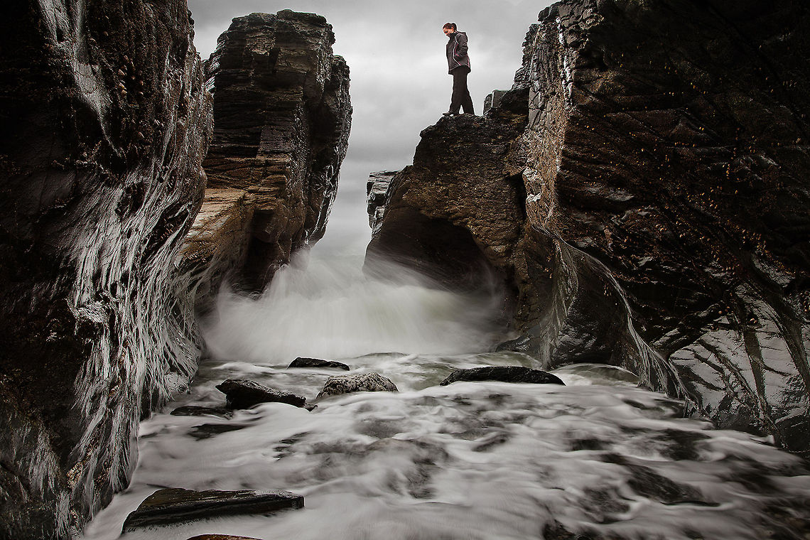 Water-_Carved_Rock_at_Godrevy,_Cornwall This was taken at Godrevy Head, Cornwall, and was rather perilous to make. I opted for a slower shutter speed to blur the water slightly, but not too much as to smooth out the movement too much. My aim was to show the relationship between the concave shapes of the rock and the gushing motion of the water. I made sure to stay fairly close to the water to maintain an in-action perspective, and I didn't mind squelching my way back to the car.  Erosion,Motion,Rushing,Water,coastal,cornwall,godrevy,nature,stone,weathering