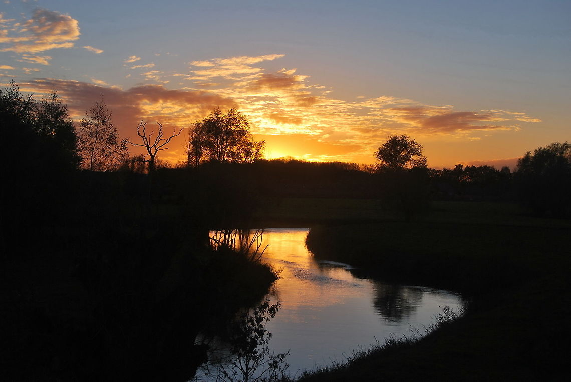 Sunset above the Dommel river Sunset above the Dommel river.<br />
At first I didn&#039;t like it when the clouds came to obscure &#039;my&#039; sunset. But eventually the clouds worked like a lamp cover spreading the light and making the scene a nice as it is. Geotagged,The Netherlands