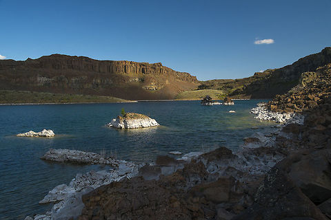 Dusty Lake Dusty Lake is a water filled pothole in Washington's Channeled Scab Lands. This fascinating landscape was formed quite differently than most scablands which are weathered and eroded gradually over 10's of  thousands or millions of years. In Washington it happened near the end of the ice age, nearly all at once (geologically speaking at least), by around 40 incredible rushes of water over about 2,000 years released from periodic breaches to the giant ice dam that formed "Lake Missoula". The lake had a volume of about 1/2 of Lake Michigan, so the volume of water that would rush out each time the dam breached was unfathomable. The Dusty and Ancient Lakes potholes are now water filled because of human activities - farm irrigation seeps into them creating lakes.

Here is an amazing arial view - Ancient Lakes is on the left and Dusty Lake is on the right - http://hugefloods.com/Scablands.html Geotagged,Spring,United States