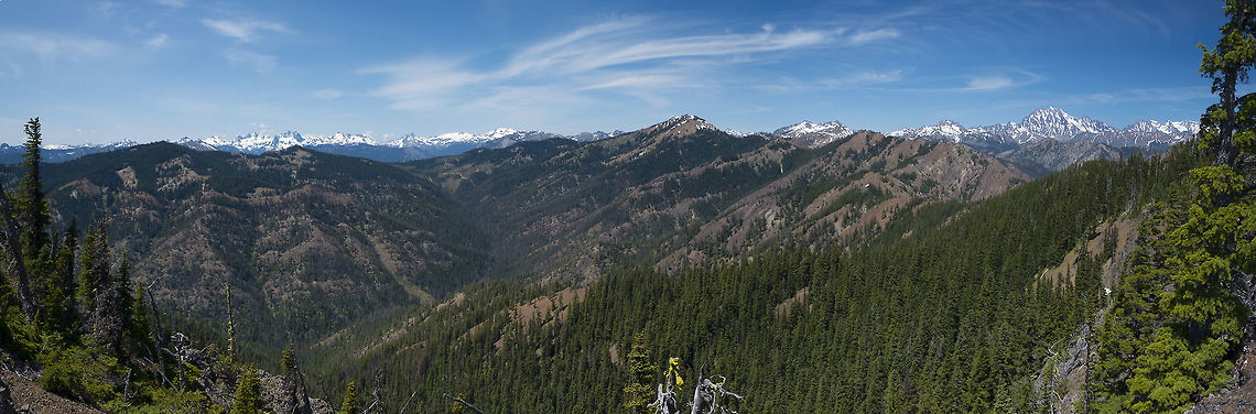 View from the unnamed peak The Stuarts are the highest mountains in the area and the pretty well the center of a large wilderness area in the middle of Washington. From just about any hike on the periphery that climbs high enough you'll get an amazing panorama of razor edged peaks that sport permanent snow fields. Venture in there and you'll find the Alpine Lakes Wilderness area. Not only is it protected from development, even recreational usage is limited in the most fragile areas. Day hikes are not restricted, but overnight use in the Enchantments area is by permit only and a limited number are given, mostly by lottery.