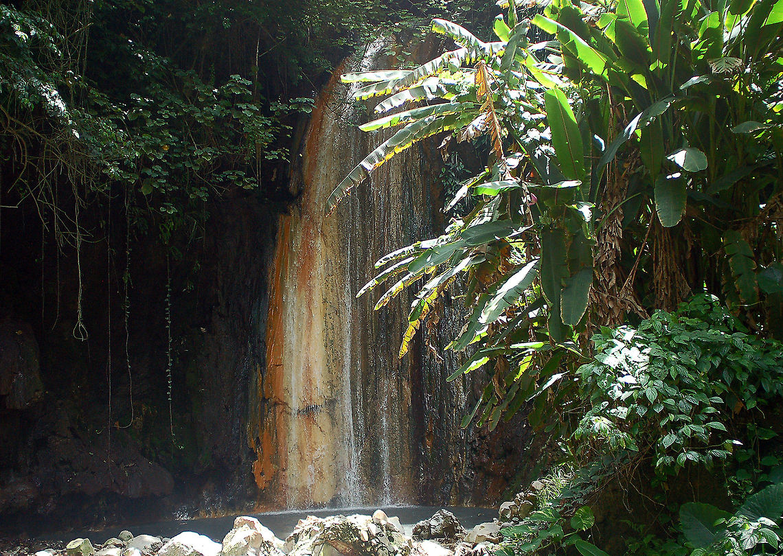 Diamond Botanical Gardens and Waterfall These splendid gardens are part of Soufri&egrave;re Estate,  St. Lucia in the Caribbean. This 2,000-acre land grant was presented by King Louis XIV in 1713 to three Devaux brothers from Normandy in recognition of their services to France. Today, the estate is still owned by their descendants; Joan Du Bouley Devaux maintains the gardens. <br />
<br />
Bushes and shrubs bursting with brilliant flowers grow beneath towering trees and line pathways that lead to a natural gorge.<br />
<br />
Deep within the botanical gardens, water bubbling from underground sulfur springs streams downhill in rivulets, forming the Diamond Waterfall. <br />
<br />
King Louis XVI of France allocated funds to build a bath house for his troops with twelve stone baths, fortifying them against the St. Lucian climate. Also here in the bath house, it is believed that Empress Jos&eacute;phine Bonaparte had bathed here as a young girl while visiting her father&#039;s plantation nearby. Diamond Botanical Garden and Waterfall,Geotagged,Saint Lucia,Waterfall