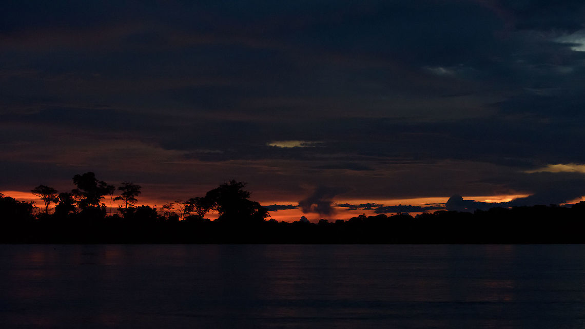 In&iacute;rida river sunset, Colombia Ending our first boat day in the Colombian Amazon. Fun fact: a few minutes before, our boat captain fell into the river. He was diving after the key of the boat's motor which he dropped into the water. And he actually recovered it.<br />
<br />
This had me wondering about the alternative scenario of losing the key: 90 minutes away (by motor boat!) from the port, outside cell phone range, minutes before sunset. Would have been an interesting night, I suppose. Colombia,Fall,Geotagged,Guain&iacute;a,In&iacute;rida,South America,World