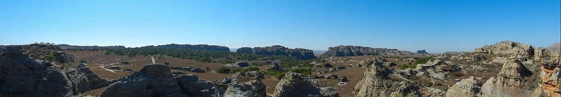 Isola mountain range (panorama) 2 Only a few hours away from the wet and cold Ranomafana rainforest is the ultra hot and dry desert mountain landscape of Isola. We took a hike here that lasted several hours. It was beautiful, but one should be warned that this walk is not without risk. The sun is very intense and there is no hiding from it. Even bringing lots of water will not help entirely, as it will heat up to be nearly undrinkeable.  Isola,Madagascar,Panorama