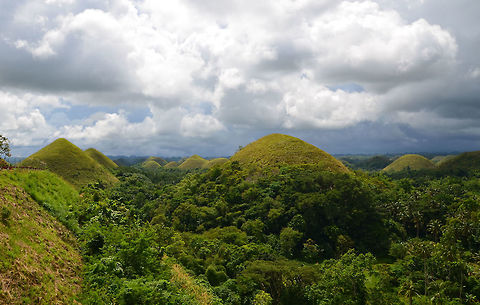 Chocolate Hills, Philippines Located in the island of Bohol, there are at least 1,260 dome-shaped limestone hills spread over an area of more than 50 square km, covered in green grass that turns brown (like chocolate) during the dry season, hence their name.
These are conical karst hills similar to those seen in the limestone regions of Slovenia, Croatia, northern Puerto Rico, and Pinar del Río Province, Cuba. They consist of Late Pliocene to Early Pleistocene, thin to medium bedded, sandy to rubbly marine limestones. These limestones contain abundant fossils of shallow marine foraminifera, coral, mollusks, and algae. The conical shape, called cockpit karst, was created by a combination of the dissolution of limestone by rainfall, surface water, and groundwater, and their subaerial erosion by rivers and streams after they had been uplifted above sea level and fractured by tectonic processes.  Fall,Geotagged,Philippines,bohol,chocolate hills,philippines,scenery