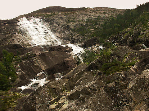 Giant rocky waterfall Near Akrafjorden we stumbled upon this waterfall. Those trees are tall and the formation goes way up. Pretty impressive, just like its country.  Geotagged,Norway,akrafjorden,waterfal
