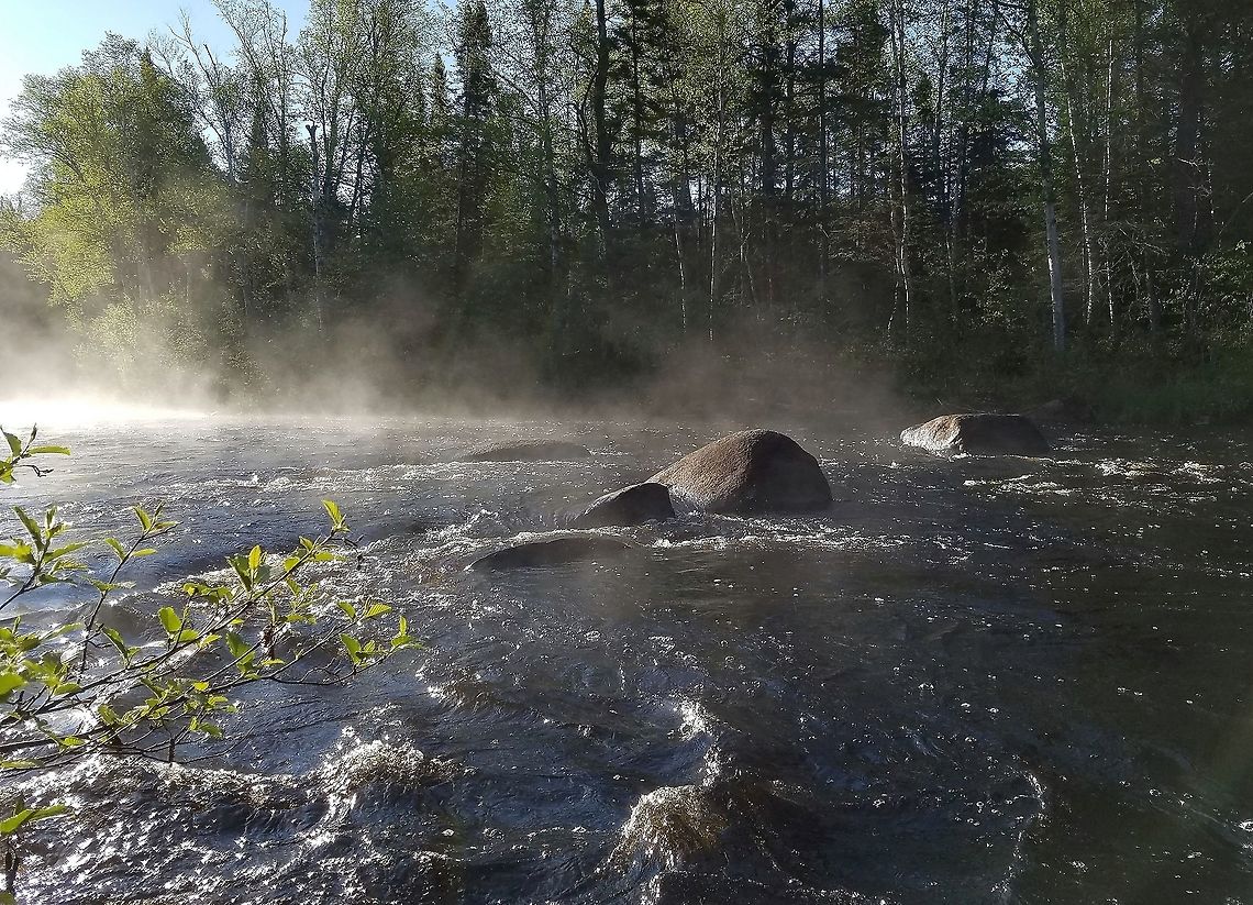Temperance River So-named because it has no (sand) bar at the mouth where it enters Lake Superior. Often said to be the only river on Lake Superior without a bar at the mouth although there are several rivers with this feature. The Ojibwa name is Kawimbash which means "deep hollow river" and is a more fitting name because in its lower reaches the river has cut a deep gorge in the igneous bedrock which resulted when numerous potholes scoured by the river later became connected. Geotagged,Spring,Temperance River,United States,fog,mist,river,water