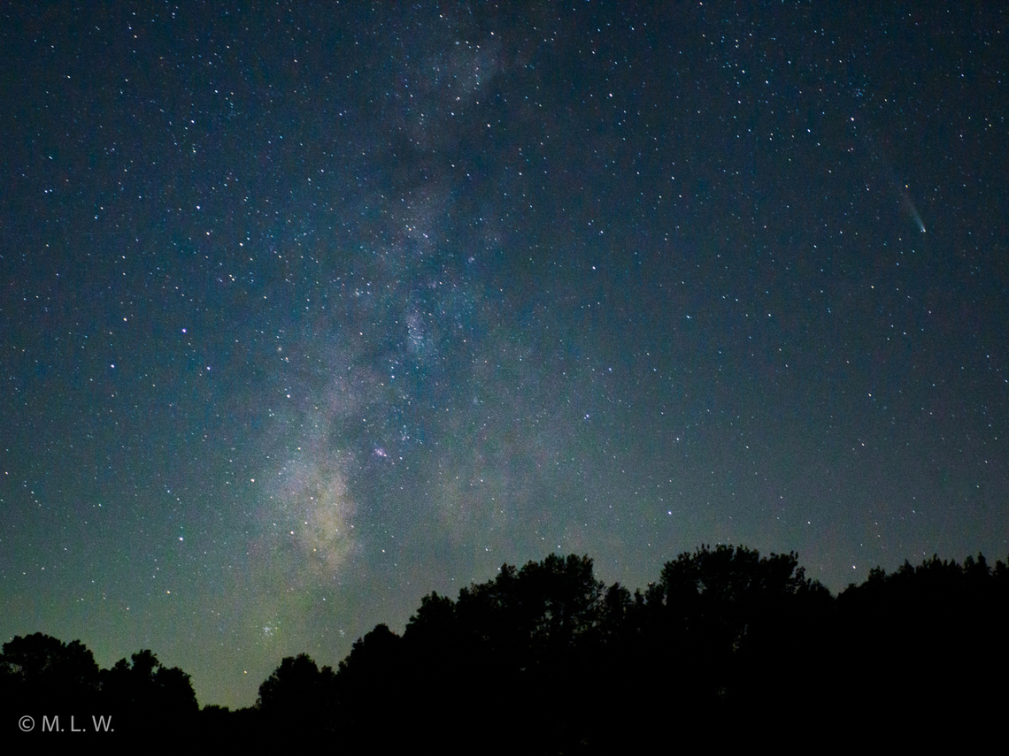 Comet C/2023 A3 (Tsuchinshan-ATLAS) Comet C/2023 A3 (Tsuchinshan-ATLAS) at the upper right of the image along with the Milky Way.<br />
20 sec. exposure, ISO 5000, f3.5<br />
OM1-MarkII, 18mm <br />
Considered a long-period comet, Comet C/2023 A3&mdash;also known as Comet Tsuchinshan-ATLAS or Comet Purple Mountain-ATLAS&mdash;recently made its closest approach to the Sun, after having traveled from the Oort Cloud. It&rsquo;s forecasted to be brightest on October 9 around magnitude -3, and around magnitude +2 on October 12 when the comet is at its closest point to Earth.<br />
Where Did C/2023 A3 Come From?<br />
Comets get the designation long-period if their orbits are more than 200 years long; C/2023 A3&rsquo;s orbit is at least 80,000 years long. It most likely came from a region called the Oort Cloud, which is a spherical volume surrounding the planets that may have formed early on in our solar system&rsquo;s history when icy objects were flung outward away from the Sun due to the gravitational action of the planets. <br />
<br />
How Was This Comet Named?<br />
<br />
Each part of a comet&rsquo;s name has a purpose! It helps us identify what kind of comet it is, when it was discovered, and where it was discovered.<br />
<br />
Comet C/2023 A3 (Tsuchinshan-ATLAS)&rsquo;s name can be broken down like this:<br />
<br />
     C/ means that this comet is classified as a non-periodic comet, which is the designation for comets that don&rsquo;t have a regular orbit around the Sun or comets whose orbits are more than 200 years long<br />
    2023 identifies the year this comet was discovered<br />
    A3 tells us the time period of the year that this comet was discovered with an alphabetic letter and a number to signify how many other comets were discovered in this time period<br />
        A = the first half of January, B = the second half of January, and so on and so forth, except the letter I and Z are never used<br />
    Tsuchinshan-ATLAS = the names of the two observatories that jointly get credit for discovering the comet. Pronunciation: [zz-jing-shan]-ATLAS. Transliteration: Purple Mountain [Observatory]-ATLAS.<br />
 Comet C/2023 A3 (Tsuchinshan-ATLAS),Fall,Geotagged,Milky Way,United States,astronomy,comet,night sky,stars