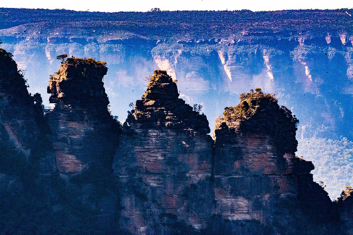 Early Morning Three Sisters Katoomba There are a number of legends. This is one:<br />
<br />
There&rsquo;s another legend that is connected to the formation of the Blue Mountains Three Sisters and offers up an explanation of how the rocks came to be.<br />
<br />
This tale begins with Tyawan, a witch doctor who had three daughters; Meenhi, Wimlah and Gunnedoo. Whenever Tyawan had to pass by a hole to get food, he would leave his three daughters behind a rocky wall on a cliff. He did this because down this deep, dark hole there lived a Bunyip who was the most feared creature on the land.<br />
<br />
One day as Tyawan passed by the hole off to get food, a large centipede crawled next to the girls and scared Meenhi so much that she threw a rock at it. The rock then fell down into the valley and angered the Bunyip. He came up to face the girls, and Tyawan who saw this from a distance turned his daughters into stones to protect them from the Bunyip with his magic bone. After he had done this, the Bunyip began chasing him so he turned himself into a lyre bird. All was well and everyone safe, however in the scuffle Tyawan had dropped his magic bone somewhere, leaving him a bird and his three daughters into the rock formations we see today. It&rsquo;s said that you can still hear the call of the lyre bird around the rocks even till now; Tyawan in search of the magic bone. Australia,Fall,Geotagged