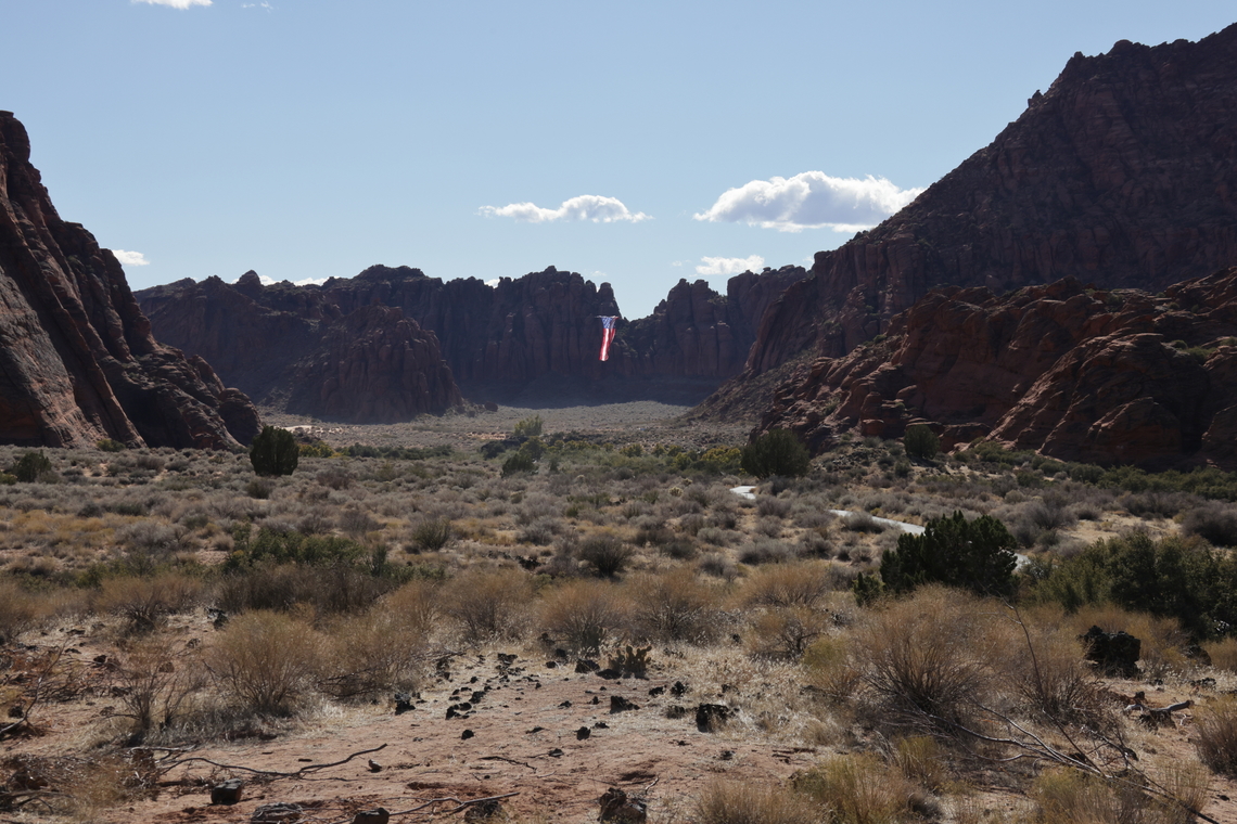 Snow Canyon St. George Utah "Follow the Flag" Surrounded by unique red sand stone cliffs and with all state permissions granted, this organization flies the United States flag around the western Unites States. It weighs 400 lbs and takes a team of people to move it it around. This flag is 150&rsquo;x78&prime; feet! A total of 11,700 square feet. The red and white stripes alone are six feet thick. This is the largest American flag to ever fly.<br />
They use a light weight but very strong Kelvar cable stretched across the red sand stone canyon peaks to position the flag.<br />
5N4A7778-1_<br />
<figure class="photo"><a href="https://www.jungledragon.com/image/164402/snow_canyon_st._george_utah_follow_the_flag.html" title="Snow Canyon St. George Utah &quot;Follow the Flag&quot;"><img src="https://s3.amazonaws.com/media.jungledragon.com/images/5803/164402_thumb.JPG?AWSAccessKeyId=05GMT0V3GWVNE7GGM1R2&Expires=1759968010&Signature=pCFMKFGRFFmi%2Bz%2FC45%2B4eYxBcig%3D" width="200" height="134" alt="Snow Canyon St. George Utah &quot;Follow the Flag&quot; Surrounded by unique red sand stone cliffs and with all state permissions granted, this organization flies the United States flag around the western Unites States. It weighs 400 lbs and takes a team of people to move it it around. This flag is 150&rsquo;x78&prime; feet! A total of 11,700 square feet. The red and white stripes alone are six feet thick. This is the largest American flag to ever fly.<br />
They use a light weight but very strong Kelvar cable stretched across the red sand stone canyon peaks to position the flag.<br />
5N4A7694-1 Fall,Geotagged,United States" /></a></figure> Fall,Geotagged,United States