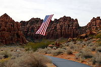 Snow Canyon St. George Utah "Follow the Flag" Surrounded by unique red sand stone cliffs and with all state permissions granted, this organization flies the United States flag around the western Unites States. It weighs 400 lbs and takes a team of people to move it it around. This flag is 150’x78′ feet! A total of 11,700 square feet. The red and white stripes alone are six feet thick. This is the largest American flag to ever fly.<br />
They use a light weight but very strong Kelvar cable stretched across the red sand stone canyon peaks to position the flag.<br />
5N4A7694-1 Fall,Geotagged,United States