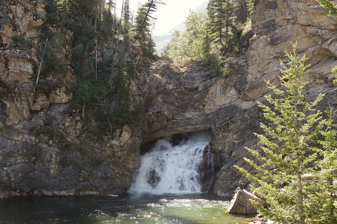 Running Eagle Falls Montana The waterfall receives its nickname, &quot;Trick Falls&quot;, because there are actually two separate waterfalls at this location. During the spring run-off, water rushes over the top ledge, creating a 40-foot drop, while completely or partially obscuring the lower falls. However, as the volume of water decreases by late summer, and the upper falls &quot;dries up,&quot; water continues to rush through a sink hole at the top of the cliff before flowing out of an opening in the cliff face below, thus creating the lower 20-foot falls.<br />
<br />
Towering prominently above the falls is 9513-foot Rising Wolf Mountain, which is named after the first white man to live with the Blackfeet Indians. Hugh Monroe, who was married to Sinopah, received his Indian name as a result of his habit of getting out of bed in the morning on his hands and knees, thus resembling a wolf. Rising Wolf Mountain also has the distinction of being the highest mountain in the Two Medicine area.<br />
<br />
The waterfall is named for Pitamakan, or Running Eagle, a female warrior leader of the Blackfeet Nation in the early 1700s, who experienced a four-day vision quest in the mountains high above the falls. Running Eagle led war parties on many highly successful raids, and was the only woman in the Blackfeet tribe ever to do so, or to be given a man&#039;s name. Geotagged,Summer,United States