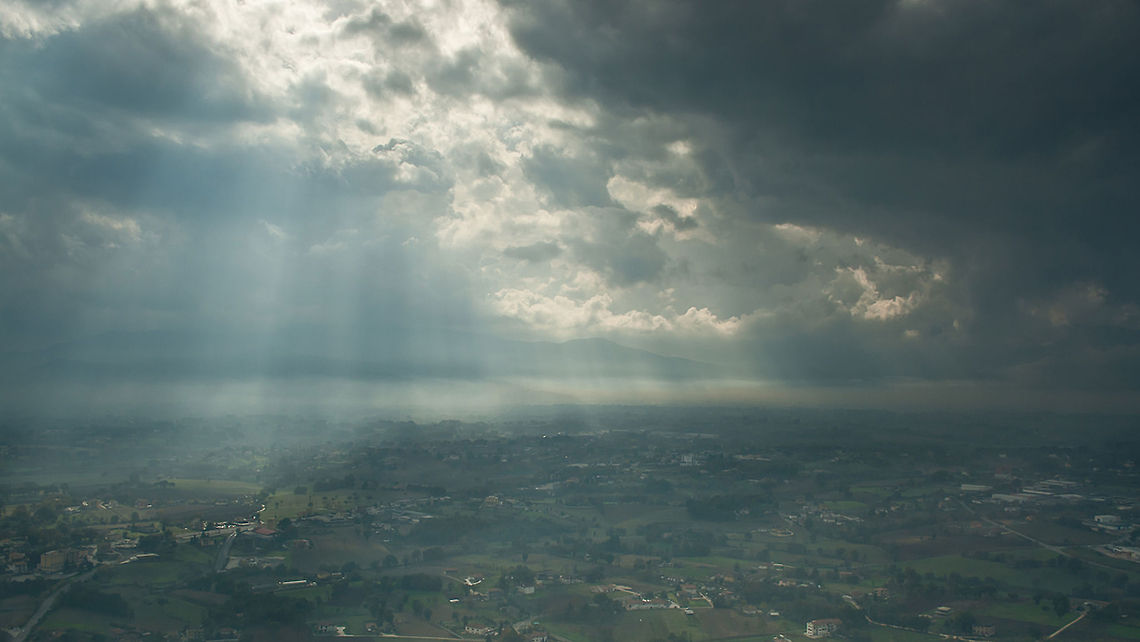 RAY OF THE SUN Shafts of sunlight break through the clouds illuminating the landscape below. Landscapes,Light beam