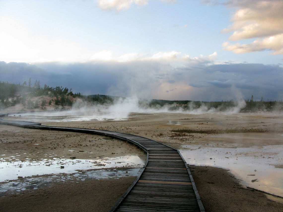 Yellowstone National Park walkway to an alien landscape An old railroad track leads the observes into a mysterious landscape of Yellowstone National Park, with geysers in the background. Landscapes,Wyoming,Yellowstone National Park