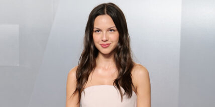 Olivia Rodrigo poses in front of a silver background