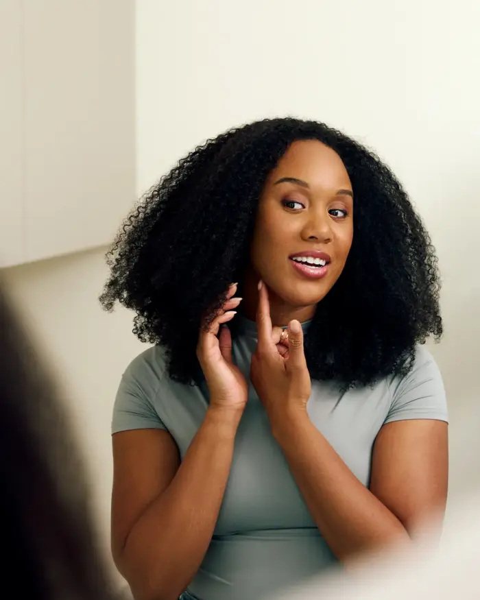 Woman looking in the mirror next to surgeon