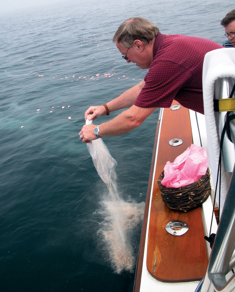 a man pouring a bag of ashes in the water