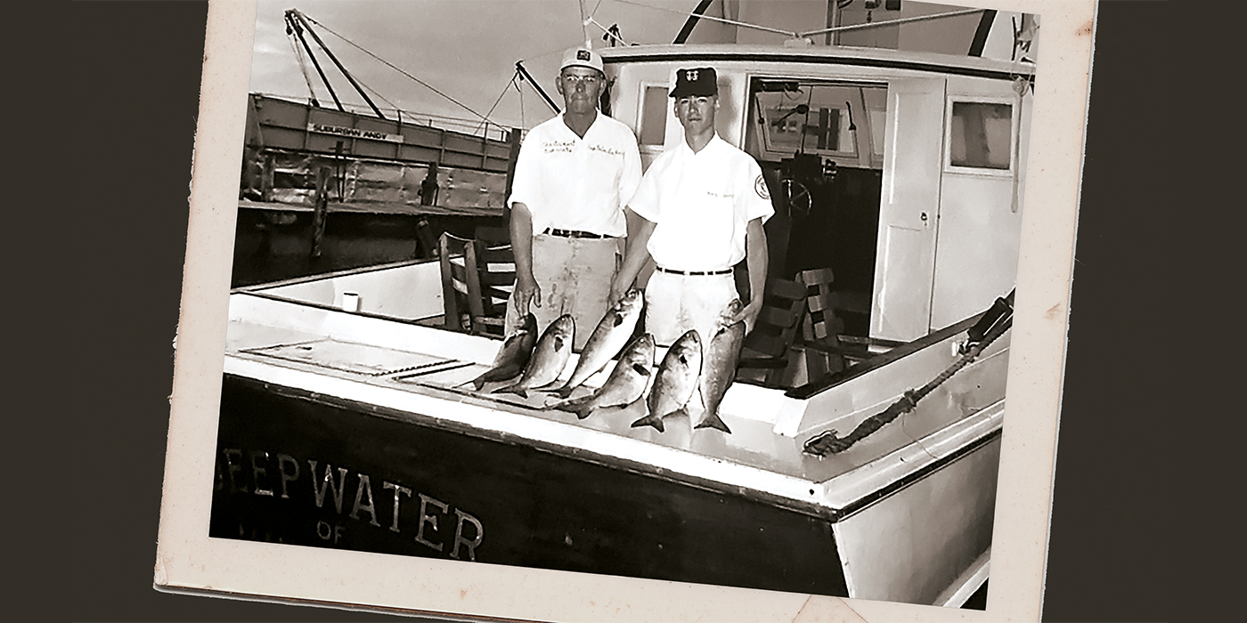 featured_LeePerry-and-SunnyBriggs Two men posing in the cockpit of a fishing boat.