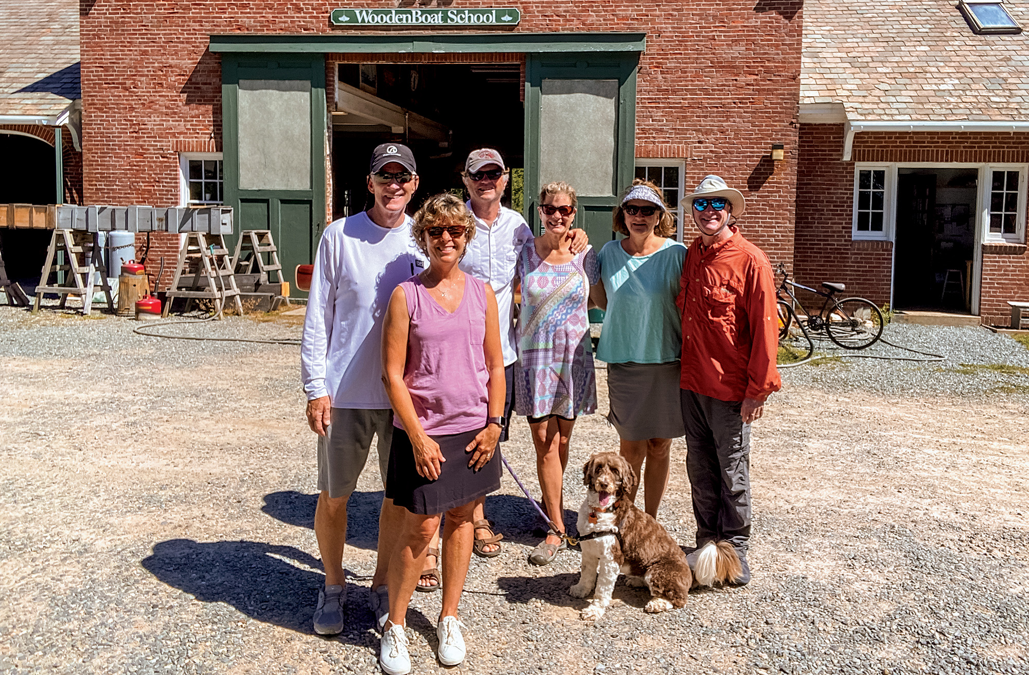 People posing in from of a barn