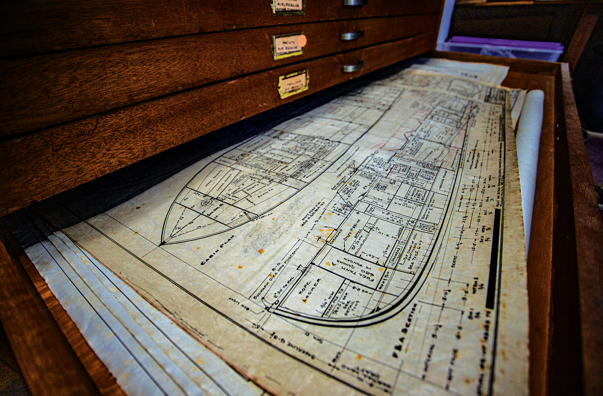 Vintage boat plans in an old wooden cabinet