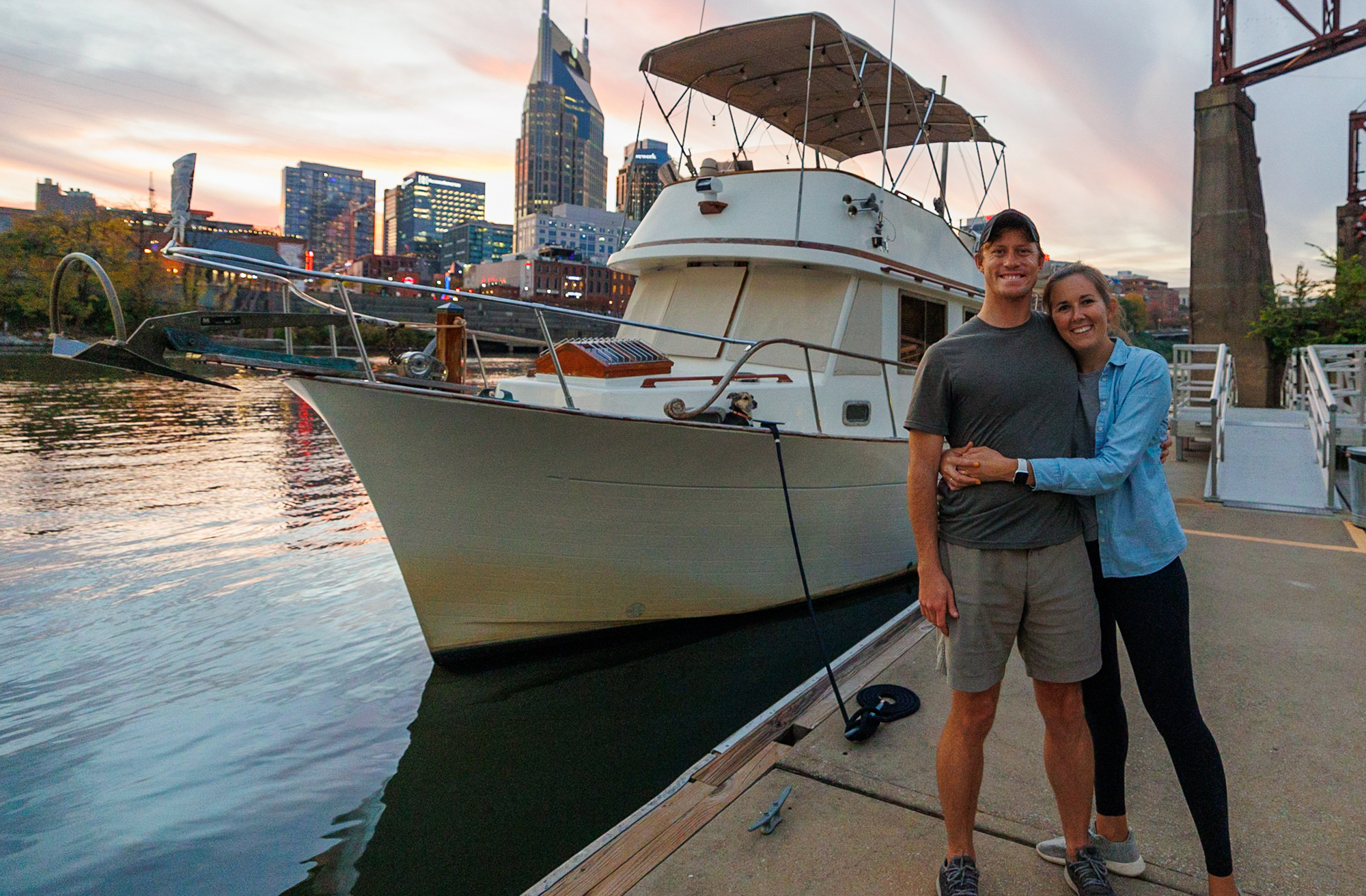 A couple standing next to a docked boat