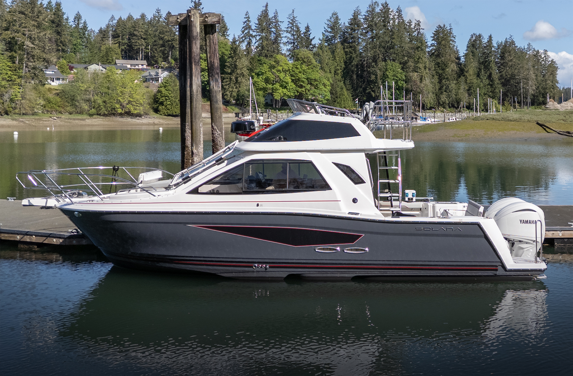 Solara S-310 Sport Bridge boat seen in profile at a dock