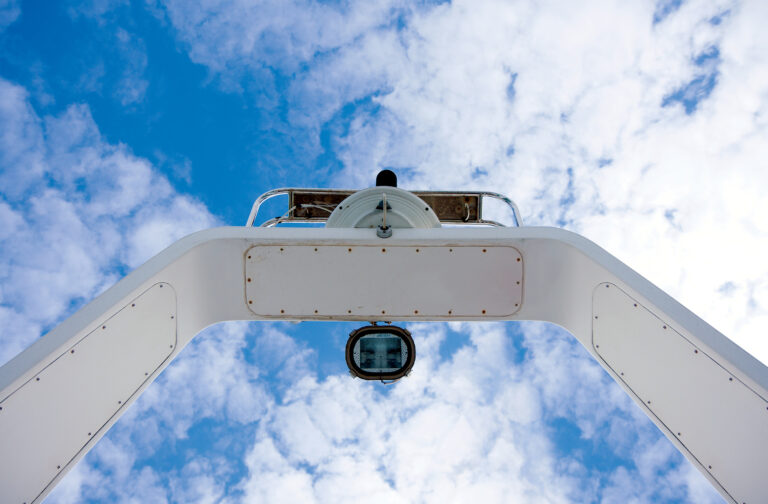 The radar arch of a modern boat against a cloudy sky,