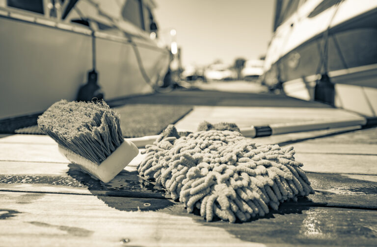 Mop and brush on a dock with boats in the background