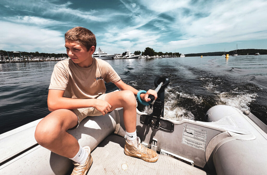 Boy driving a dingy with an electric outboard