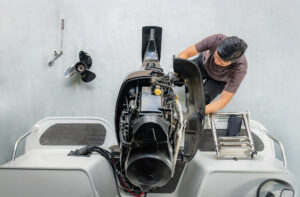 Repairing engines on aluminum boats , The technician is removing the boat parts to make the paint