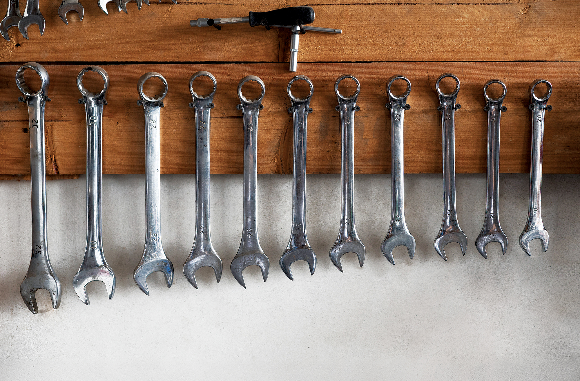 A set of wrenches hanging on a wooden stand in the garage. Works A set of wrenches hanging on a wooden stand in the garage. Works
