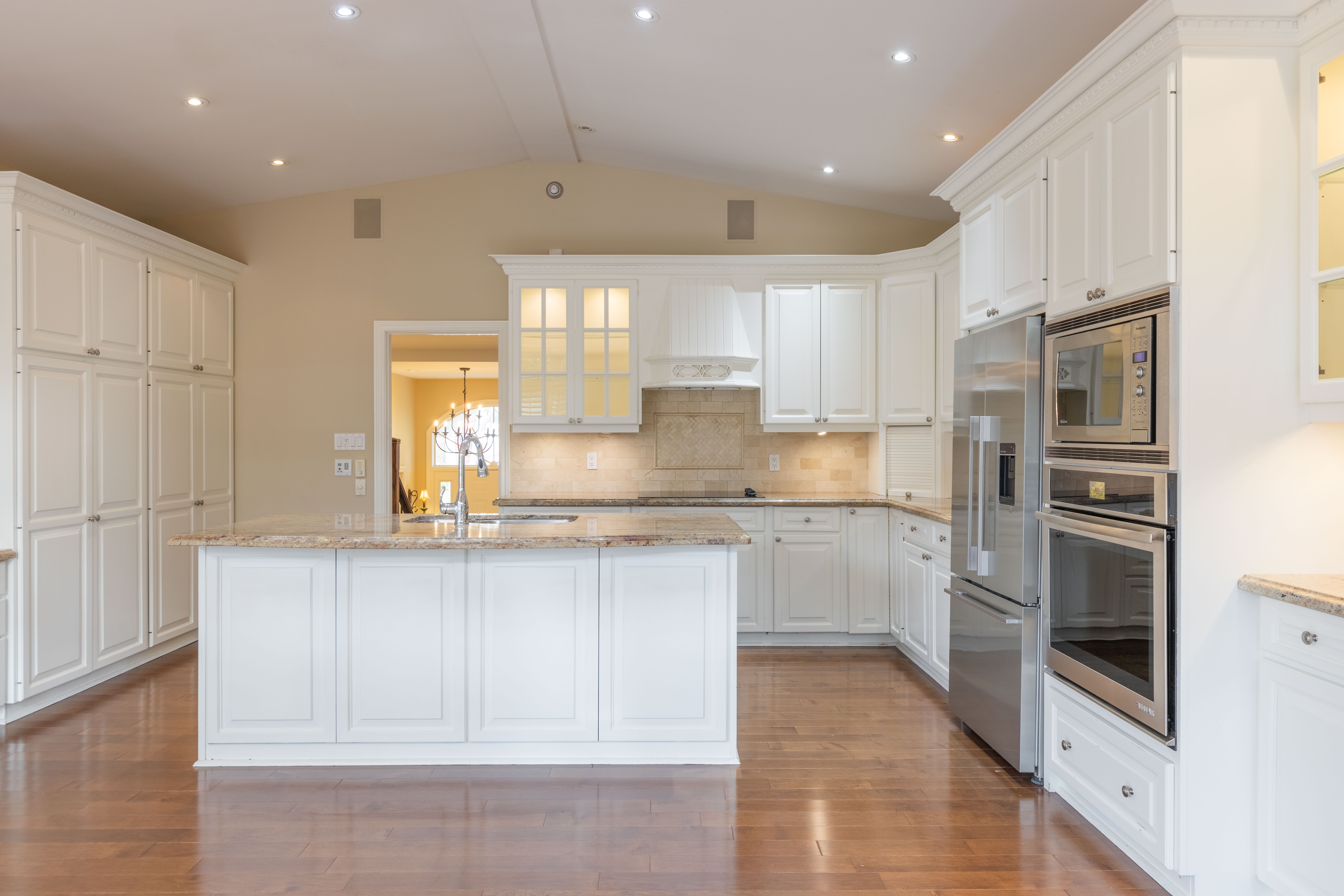 Modern kitchen with white cabinetry, stainless steel appliances, and hardwood flooring