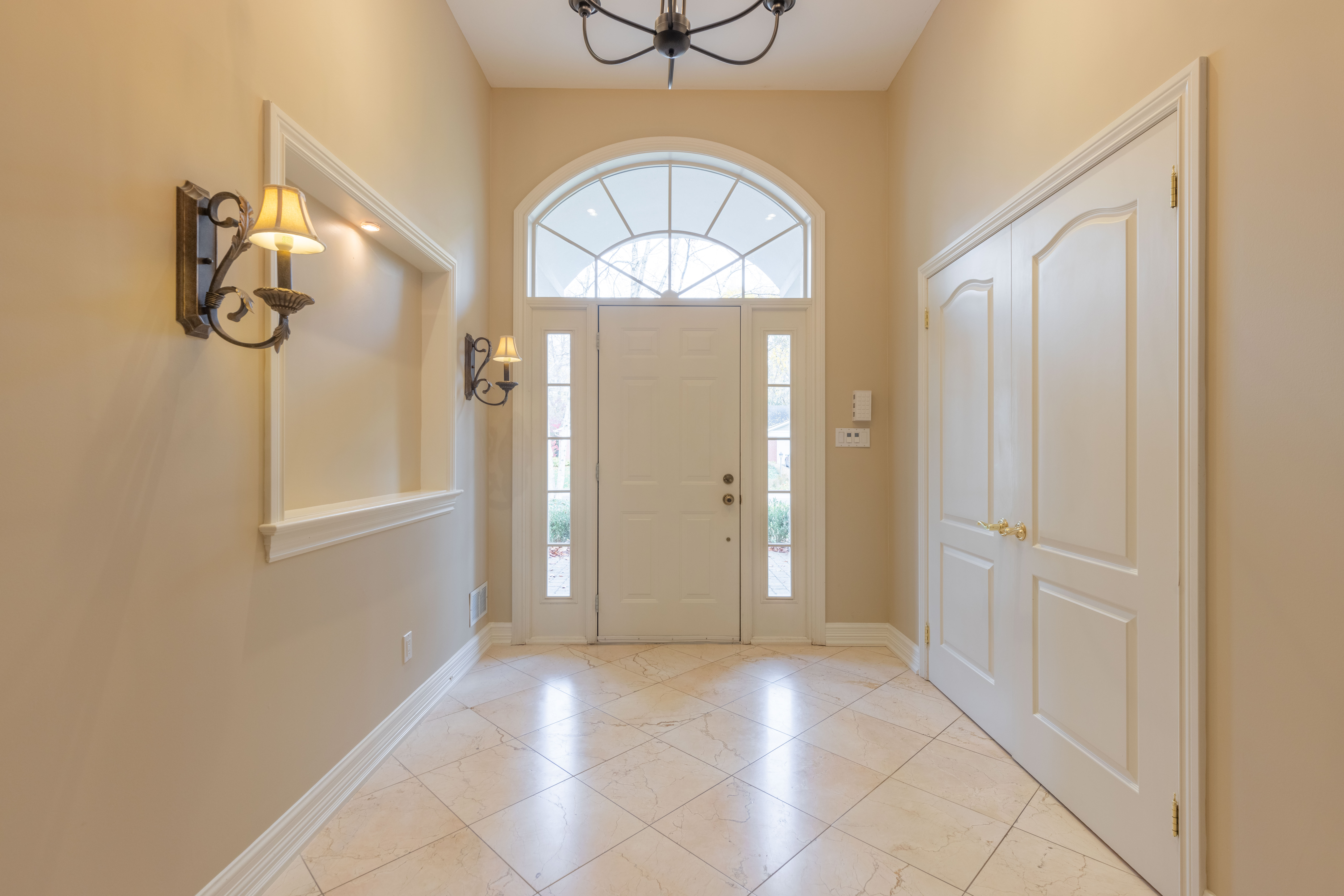 Bright entryway with a large window and elegant light fixtures