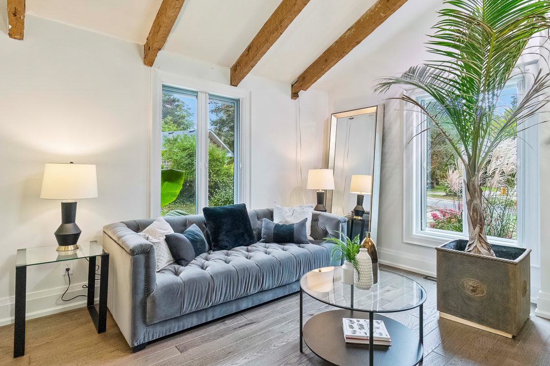 Modern living room with a gray tufted sofa and large windows