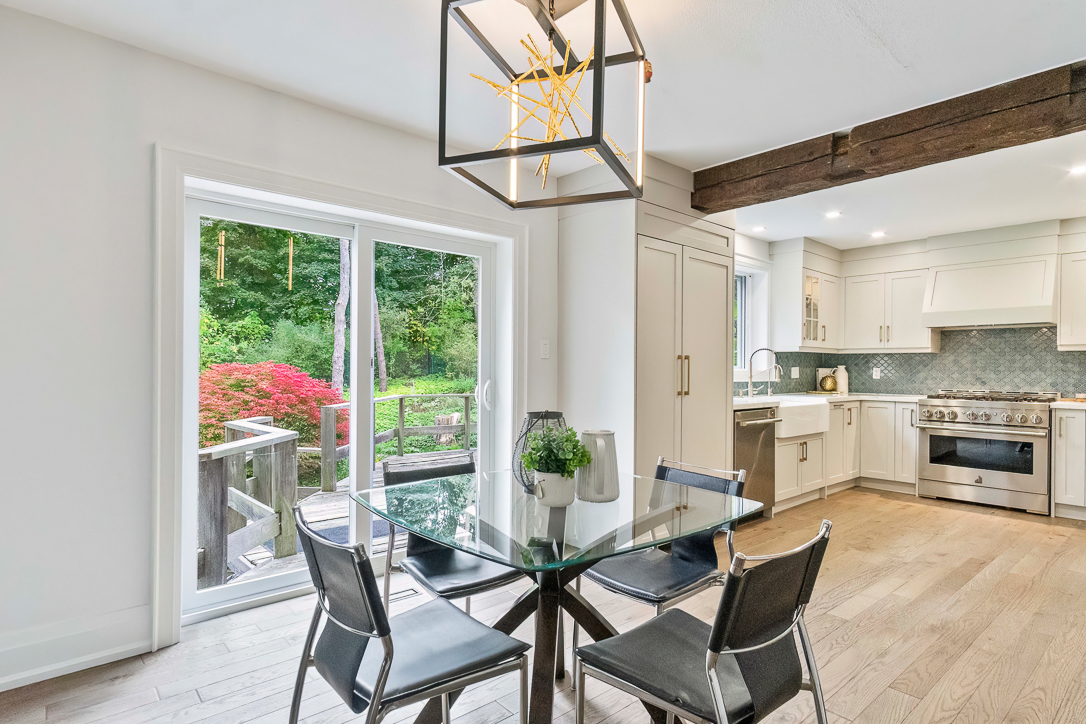 Modern kitchen and dining area with glass table and outdoor view