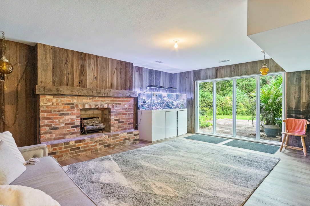 Cozy living room with a brick fireplace and large glass doors to the garden
