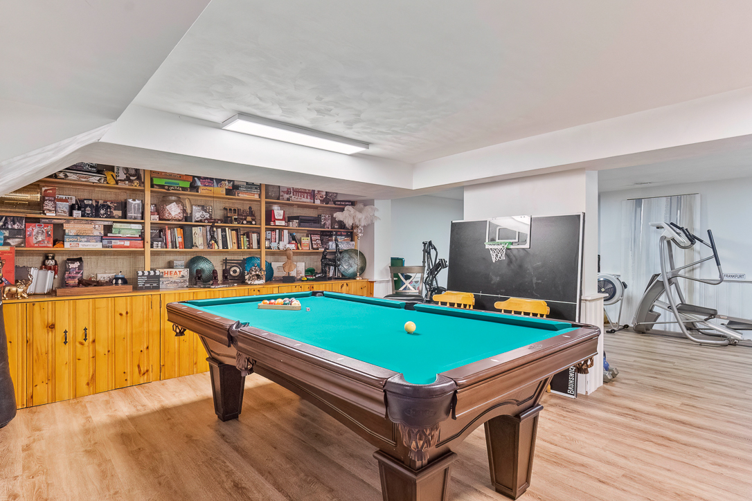 Game room featuring a pool table, shelves of games, and exercise equipment